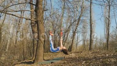 这名女子在训练<strong>气</strong>引力时，挂在树上的绳子上